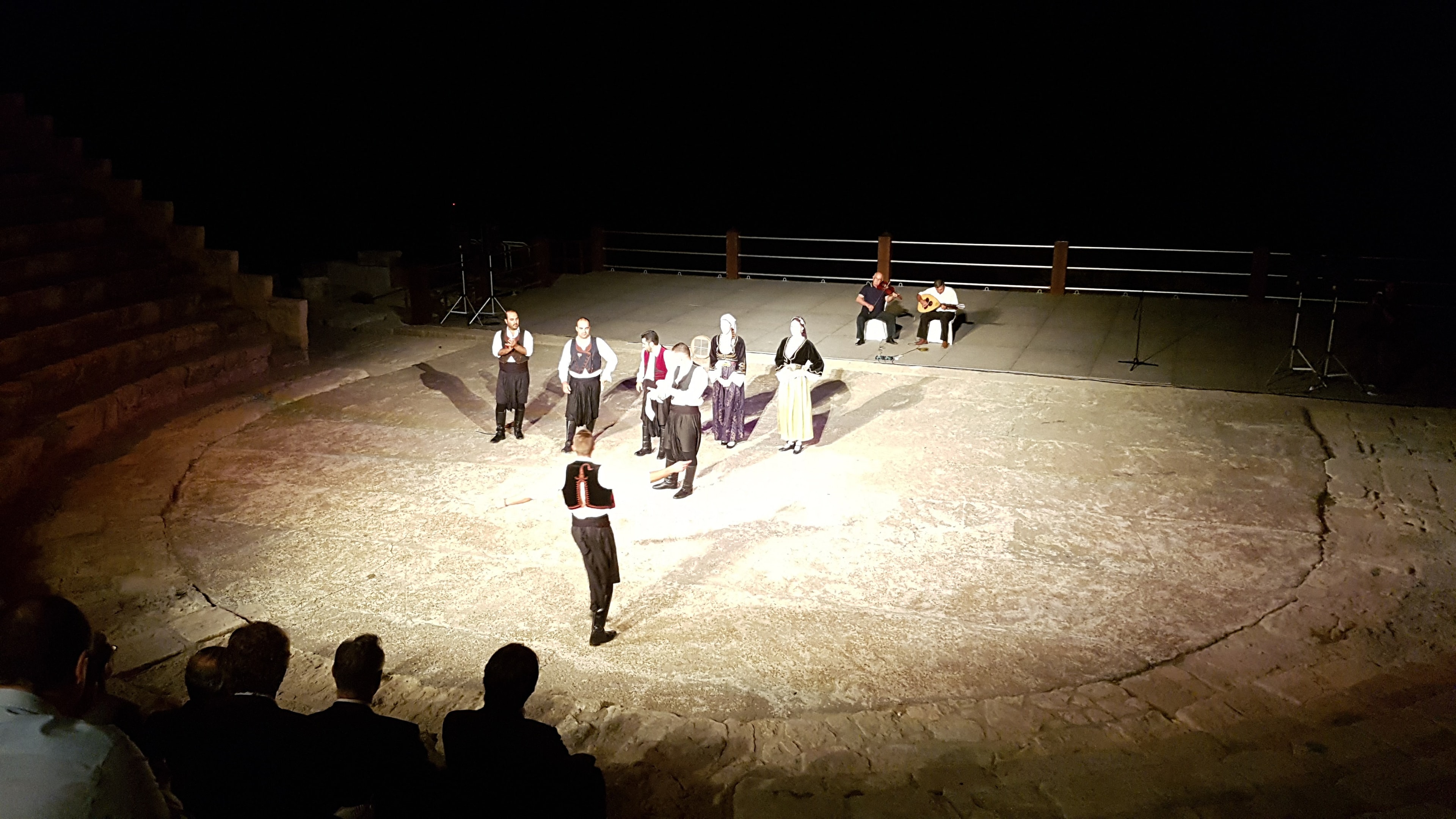 Audience watching performers on the ancient amphitheatre stage