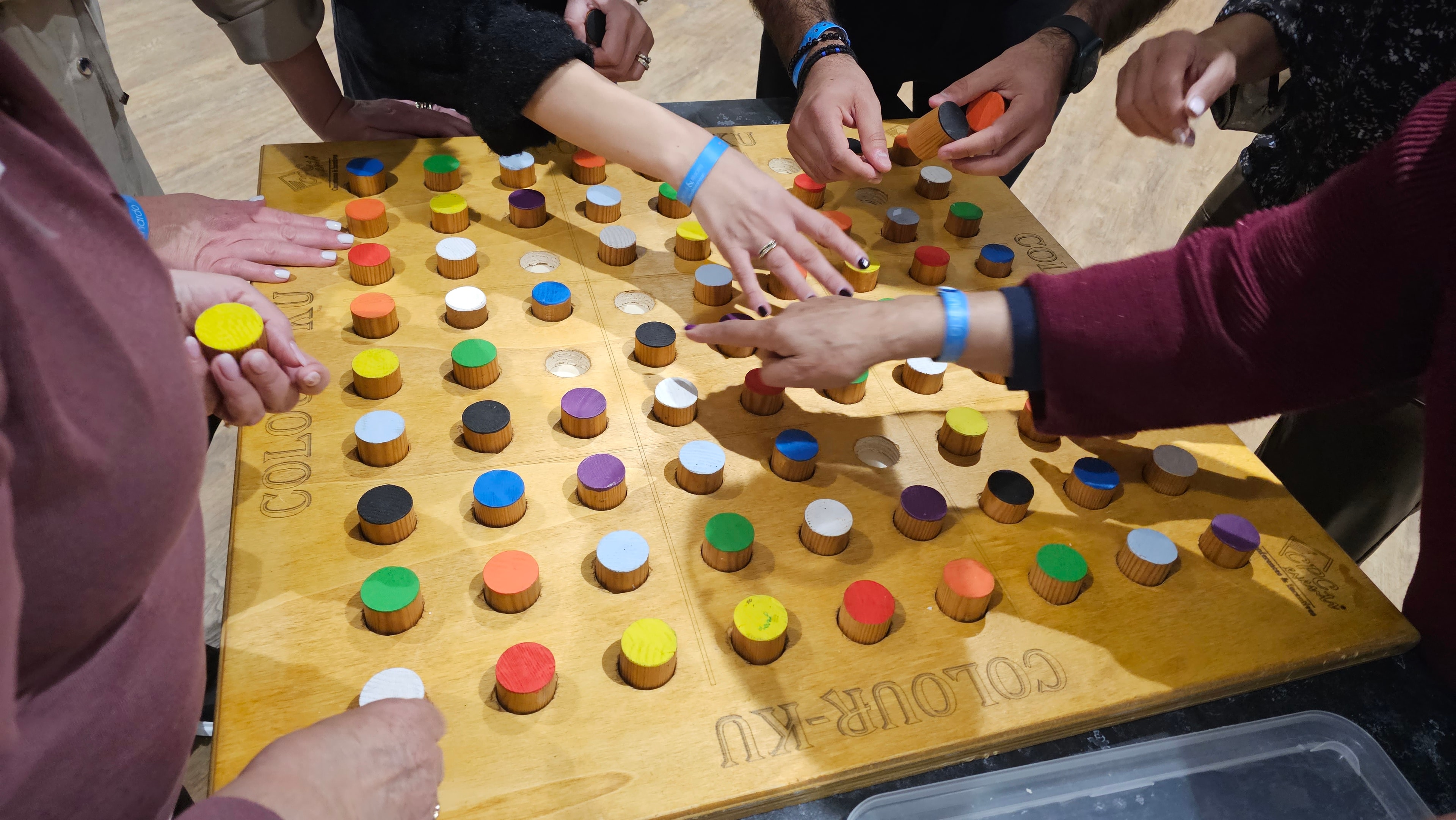 Participants working together on a colourful wooden mind game